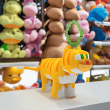 Load image into Gallery viewer, Minecraft 5 Inch Cat Bag Hanger Plush with clip and pixelated detailing displayed on store counter.
